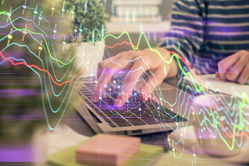 Double exposure of woman hands typing on computer and forex chart hologram drawing. Stock market...