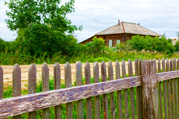 Fototapeta na wymiar Old wooden fence, hedge, in a Russian village.