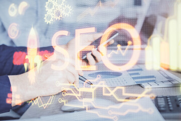 Multi exposure of man's hands holding and using a digital device and seo drawing. search...