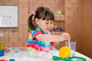 Obraz na płótnie Canvas toddler girl play science experiments for homeschooling