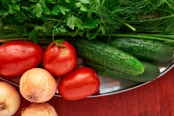 healthy food - fresh vegetables and greens on a wooden background, greens, onion and tomatoes
