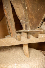 Inside view of a watermill with its millstone and grain hopper