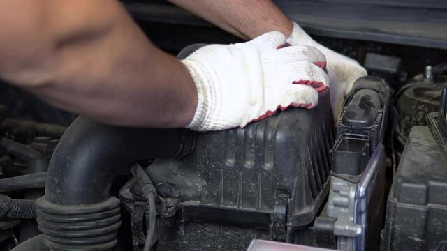 Repairman closes air filter cover after replacement