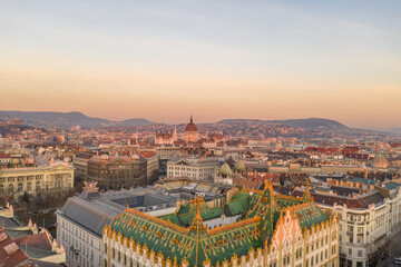 Aerial drone shot of art nouveau rooftop postal bank in Budapest dawn with Parliament view