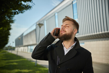 Urban business man talking smart phone traveling walking outside airport. Casual young businessman wearing suit jacket. Handsome male model in 20s, Manager, City Hall, cell. Close up