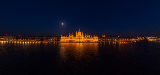 Fototapeta na wymiar Panoramic aerial drone shot of front facade of Hungarian Parliament with lights on in Budapest night