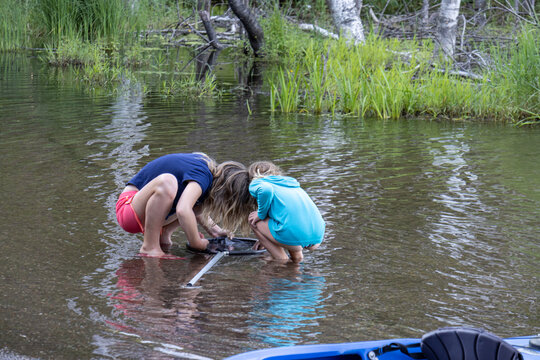 two girls in the water with fishing net