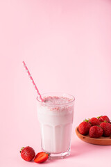 Fresh milkshake with strawberries on pink background. Summer detox drink. Place for text.