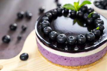 Round blueberry vegan cheesecake with berries and mint leaves on top