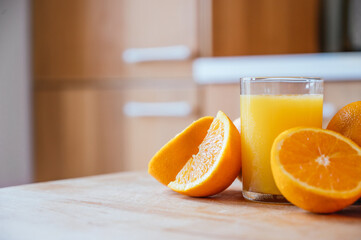 Healthy orange juice with sliced oranges on a wooden table