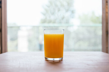 Healthy orange juice with sliced oranges on a wooden table