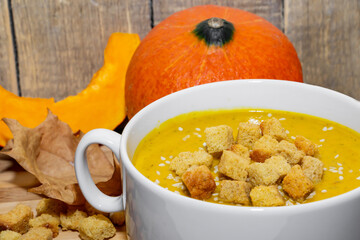 Autumn pumpkin soup with sesame seeds on a wooden background