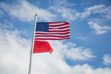 American Flag and Red Flag Flying at the Beach - High Hazard
