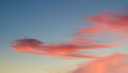 Nuvens no céu azul ao por do sol com tons de cores vermelhas