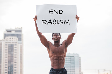 African American man holding a poster and screaming in protest, end to racism