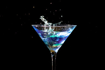 Splash in martini glass, shot in studio on dark background
