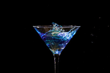 Artistic Splash in Martini Glass with Vibrant Blue Liquid Isolated on Black Background
