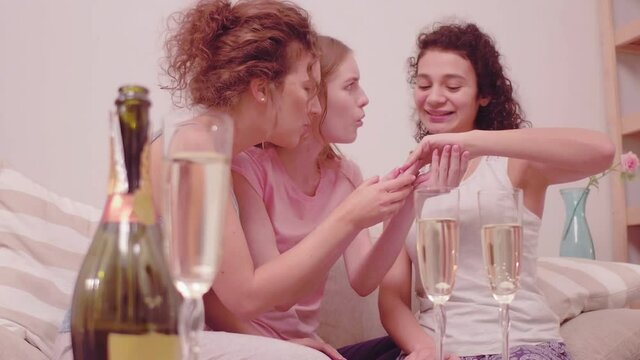 Girls looking at ring of their friend. Best friend engagement party for girls. Girl showing her ring. Having time together with champagne. Close up image of women hands. toned footage. Prores 422. 
