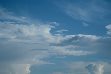 White cirrus clouds on a background of dark blue sky.