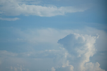 White cirrus clouds on a background of dark blue sky.