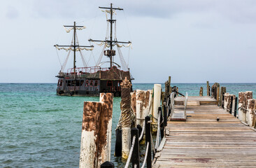 dramatic seascape image of aqua blue caribbean water with a pirate ship in harbor in Punta Cana,...