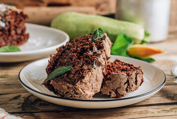 Vegan crunchy chocolate zucchini cake on rustic wooden. Healthy gluten free food.