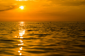 Amazing sea sunset on the pebble beach, the sun, waves, clouds