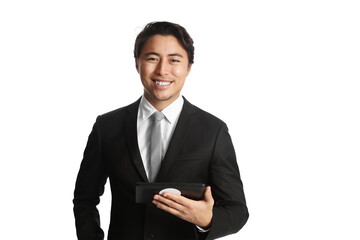 Fashionable and attractive young businessman holding a digital tablet reader, wearing
a black suit, grey tie and white collared shirt standing against a white background.