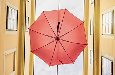 Red umbrella hanging out above old passage street in Vienna