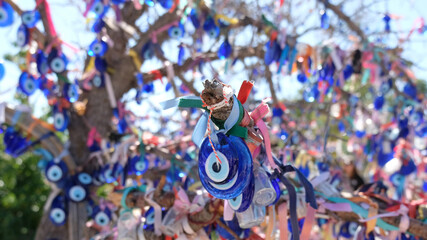 close up of blue and white trinkets hanging from a tree