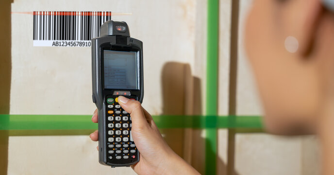 handheld barcode reader scanning barcode tag on boxes in warehouse