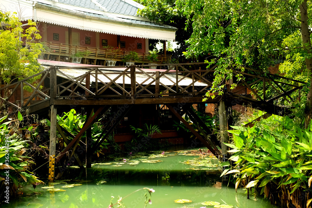 Canvas Prints Wood bridge across a pond before vintage houses