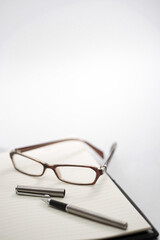 Glasses and pen on note book