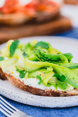 Raw zucchini and goat cheese crostini with mint leaves