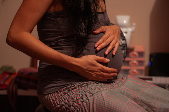 Mujer embarazada tocándose la barriga sintiendo a su bebe 