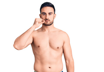Fototapeta premium Young handsome man wearing swimwear mouth and lips shut as zip with fingers. secret and silent, taboo talking
