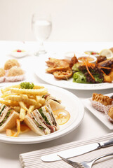 Club sandwich, fried yam puffs, fried puff pastries, and bruschetta served with chicken wings
