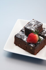 Brownies with icing sugar and strawberry