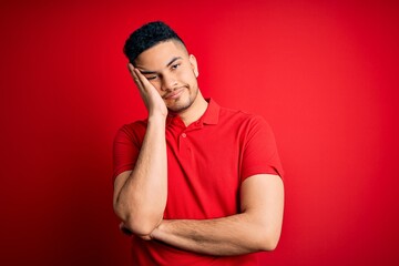 Young handsome man wearing red casual polo standing over isolated background thinking looking tired and bored with depression problems with crossed arms.