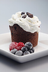 Chocolate chip muffin with whipped cream and berries