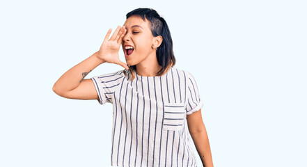 Young woman wearing casual clothes shouting and screaming loud to side with hand on mouth. communication concept.