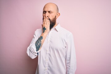 Handsome bald man with beard wearing elegant shirt over isolated pink background bored yawning tired covering mouth with hand. Restless and sleepiness.