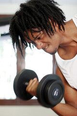 Obraz premium An African American man lifting a dumbbell with his right hand