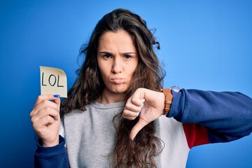 Young beautiful woman with curly hair holding reminder paper with lol message with angry face,...