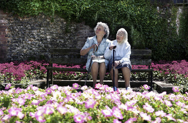 Two old women sitting on a bench in the garden