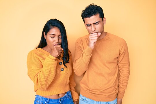 Beautiful latin young couple wearing casual clothes together feeling unwell and coughing as symptom for cold or bronchitis. health care concept.