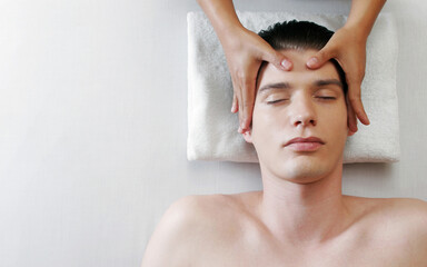 Top view of a pair of hands massaging the head of a man
