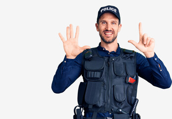 Young handsome man wearing police uniform showing and pointing up with fingers number seven while smiling confident and happy.