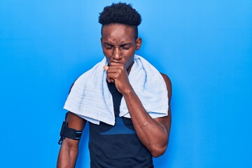 Young african american man wearing sportswear and towel feeling unwell and coughing as symptom for...