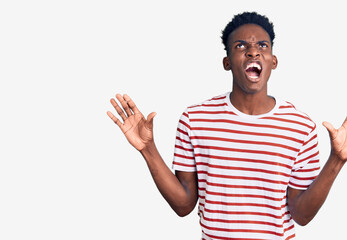 Young african american man wearing casual clothes crazy and mad shouting and yelling with aggressive expression and arms raised. frustration concept.